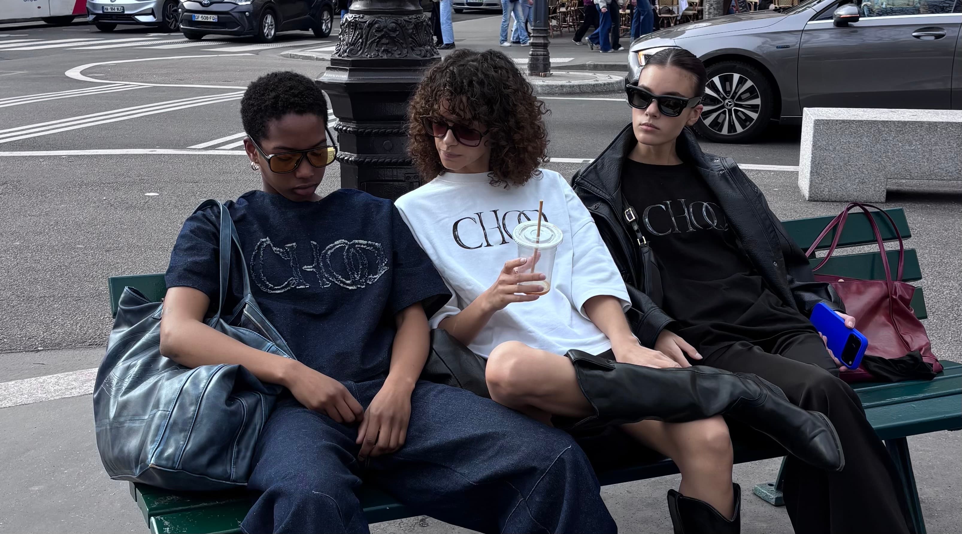 Three friends wearing CHOQ tees sitting on a Paris street bench